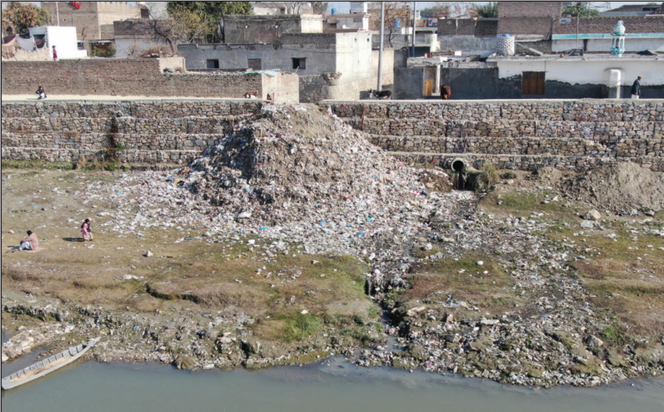 Municipal waste dumped down a riverbank beside a settlement